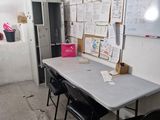 a table and chairs in a room with a whiteboard on the wall