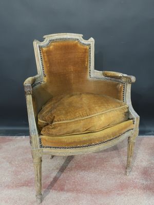an old chair with a yellow velvet upholstered seat
