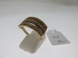 gros plan d'une bague sur une surface blanche avec une étiquette de prix