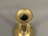 an antique brass candle holder with a green glass in the middle