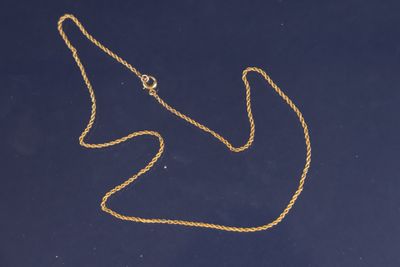 une image représentant un collier en or sur un fond bleu