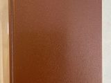 an open brown book sitting on top of a table next to a cup of coffee