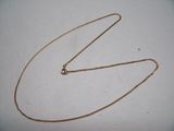a close up of a gold chain on a white surface