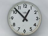 a white clock with black hands on a white wall