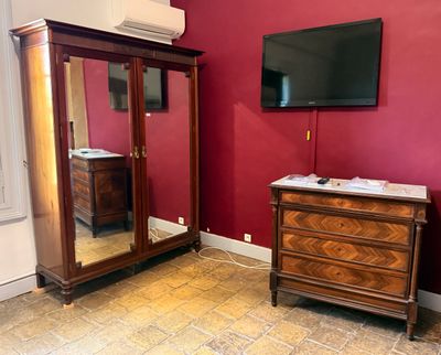 une commode et un miroir dans une pièce aux murs rouges