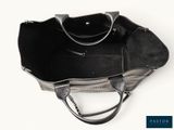 the large black bag is sitting on a white surface