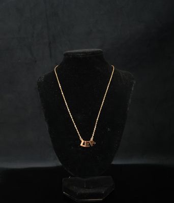 un collier en or sur un mannequin, sur fond noir