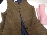 a brown vest and a pink sweater sitting on a table