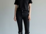 the woman is wearing black jeans and a black t - shirt