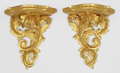 paire de supports muraux anciens en bois peint en doré, ornés de volutes et de volutes