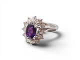 un gros plan d'une bague ornée d'une pierre violette entourée de diamants blancs