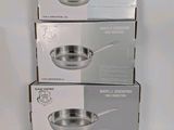 three boxes of stainless steel pans stacked on top of each other