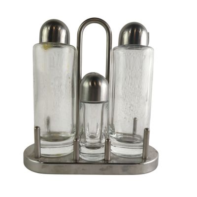 three salt and pepper shakers in a metal holder