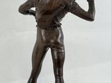 bronze statue of a man holding a baseball bat on a wooden base