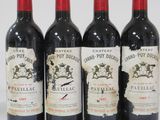 four bottles of wine are lined up in a row on a white surface