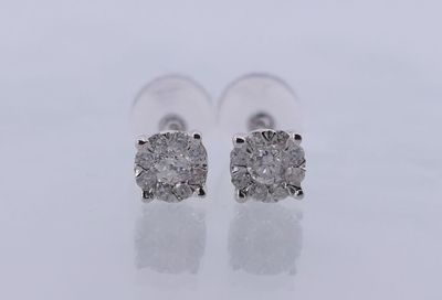une paire de boucles d'oreilles en diamant sur une surface blanche