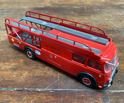 un bus rouge à deux étages posé sur une table en bois