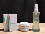 deux flacons de lotion et une boîte de lotion posés sur une table en bois