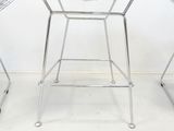 three chairs and a table in a room with a white wall
