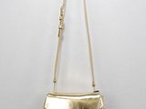 a gold purse hanging on a wall with a chain