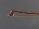 a close up of a bow with a wooden handle on a gray background