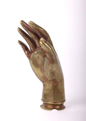 a bronze statue of a hand holding something in it ' s right hand