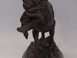 bronze statue of a bear holding a bird on a marble base