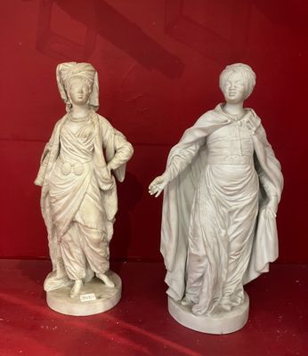 two statues of a woman and a man on a red surface
