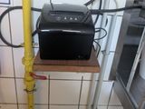 a toaster sitting on top of a wooden shelf in a kitchen