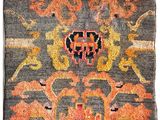 an antique rug with a floral design on a grey background