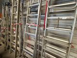 several ladders are lined up against a wall in a warehouse