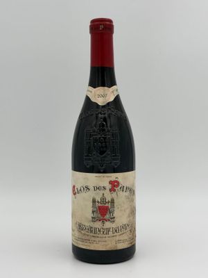 a bottle of red wine sitting on top of a white table