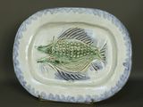 une assiette avec un poisson dessus, posée sur une table