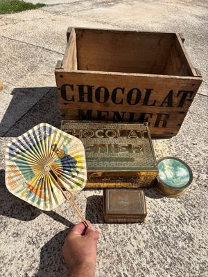 une personne tenant un éventail en papier à côté d'une boîte de chocolats