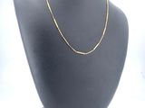 a close up of a necklace on a mannequin with a white background
