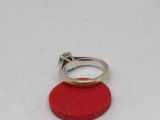 a silver ring with a diamond on top of a red circle