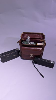 un sac en papier brun contenant un appareil photo et d'autres objets