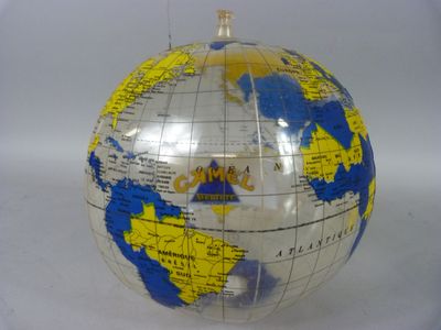 un petit globe terrestre orné d'une carte, posé sur une surface blanche