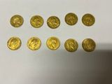 a bunch of gold coins sitting on top of a white table