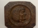a wooden plaque with a picture of a woman on it
