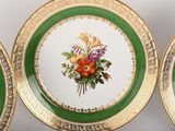 three green and gold plates with flowers on them on a white surface