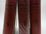 three red books sitting on top of each other on a white surface