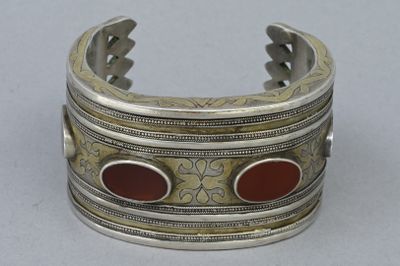 bracelet manchette en argent orné de pierres rouges sur un fond blanc