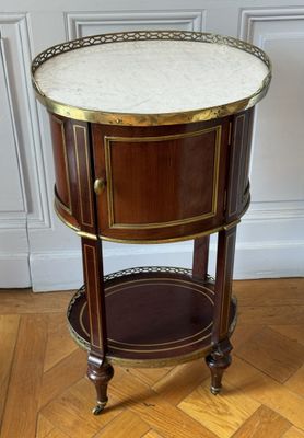 une table d'appoint ancienne avec un plateau en marbre posée sur un parquet