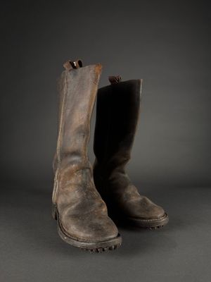 an old pair of brown leather boots on a black background