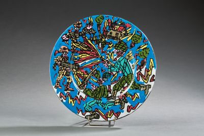 une assiette bleue décorée, posée sur un socle