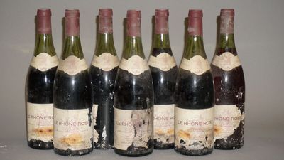 six bouteilles de vin sont alignées sur une table