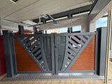 un grand portail métallique muni d'une porte rouge, dans un immeuble