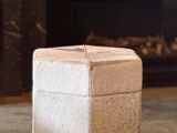 a small white box sitting on the floor in front of a fireplace