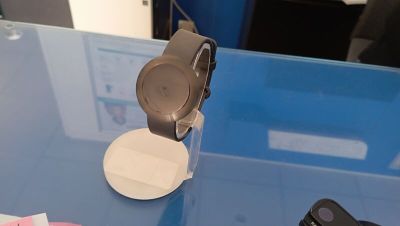 une montre connectée posée sur une table, à côté d'une télécommande